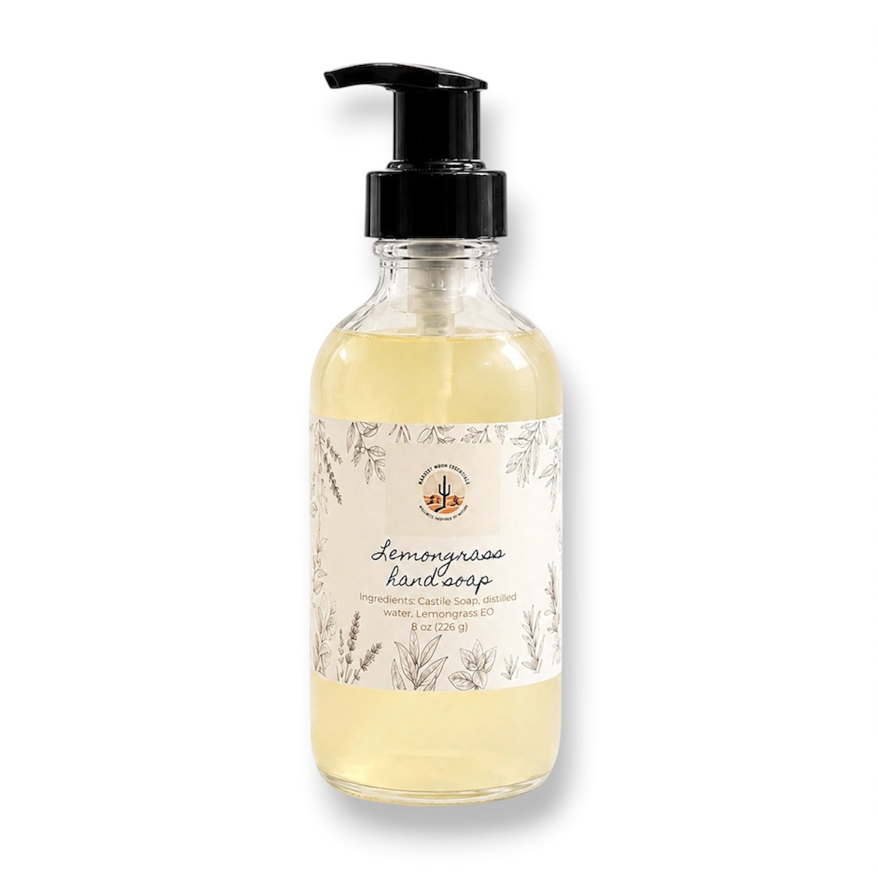 A bottle of Lemongrass Hand Soap by The Soap Society, featuring a clear glass bottle filled with pale yellow liquid, a black pump dispenser, and a white botanical label.