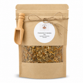 Kraft paper packaging with dried herbs and a wooden scoop on a white background